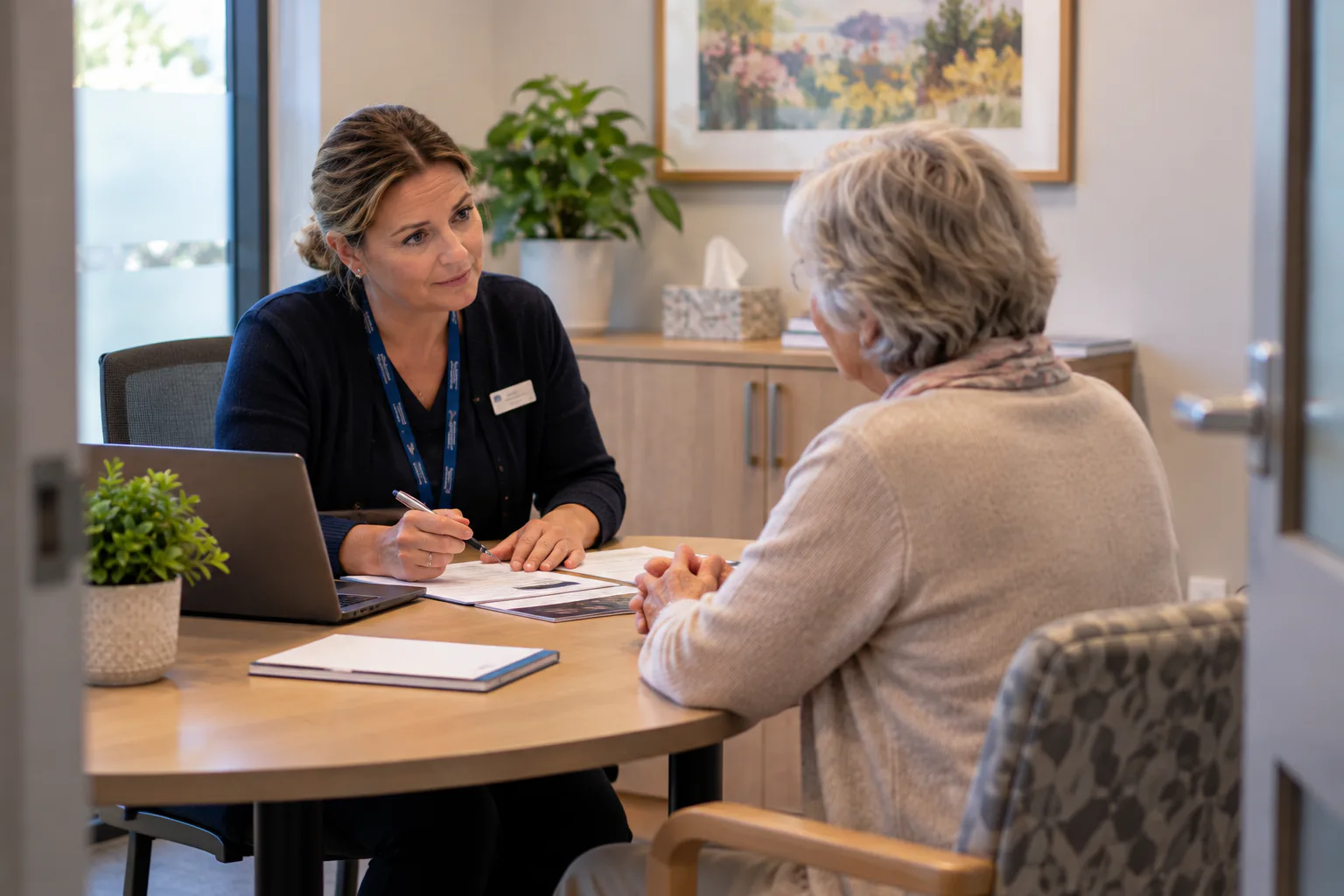 Staff member meeting with a resident at a table in a quiet interview room