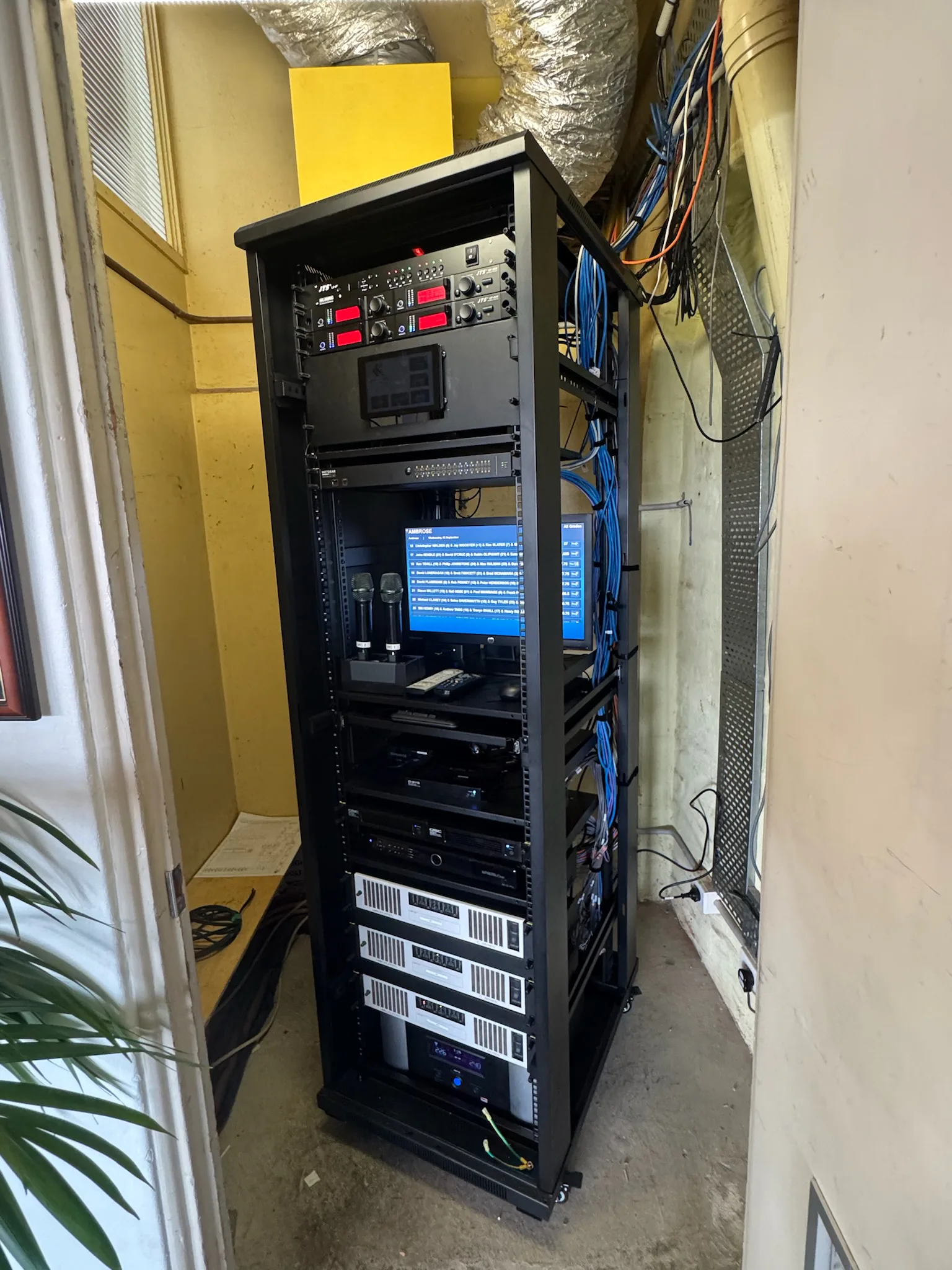 The rebuilt equipment rack after the upgrade — amplifiers, radio mic receivers, switching and control racked, tidied and ready for use
